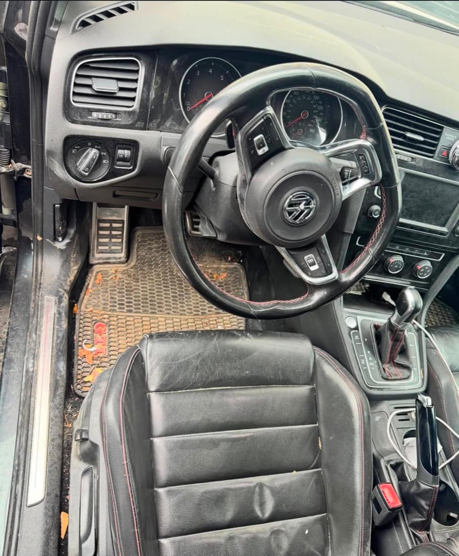 VW Golf GTI driver cockpit before detailing — dusty dash, dirty floor mat and seat